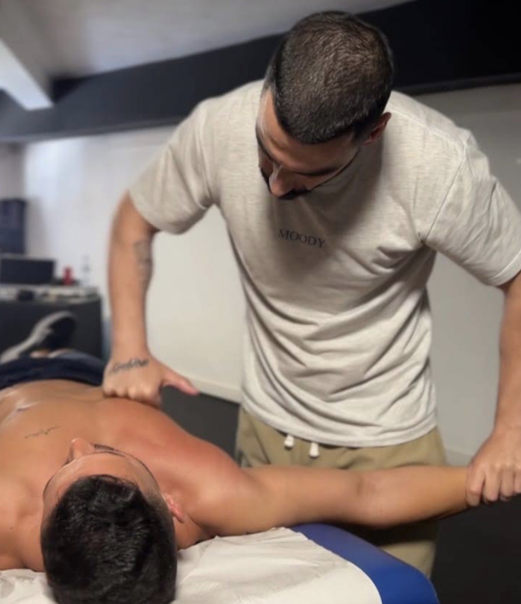 Hugo Mesquita a realizar a mobilização do braço de um cliente durante uma sessão